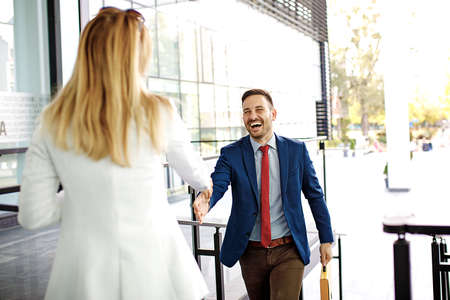Young business people in front of company building having handshake.の写真素材