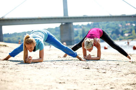 Two young women are exercising on the beach.の写真素材
