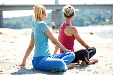 Two young women are exercising on the beach.の写真素材