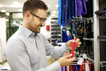 Portrait of handsome young man buying bowtie in the store.の写真素材