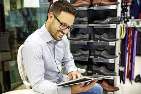 Portrait of handsome young man buying clothes in the store.の写真素材