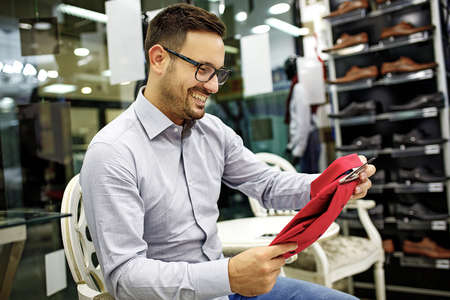 Portrait of handsome young man buying clothes in the store.の写真素材