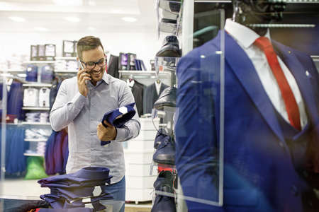 Portrait of handsome young man buying clothes in the store.の写真素材