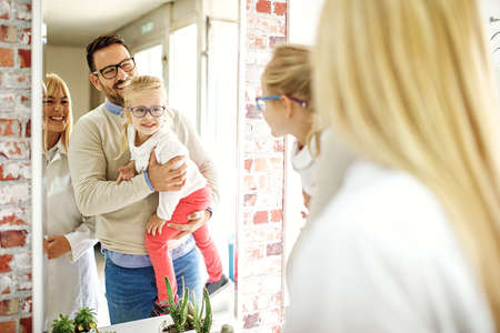 Happy family choosing glasses in optics store.の写真素材