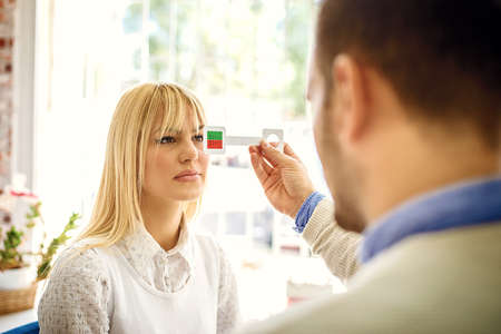 Woman is checking eyesight in optics store.の写真素材