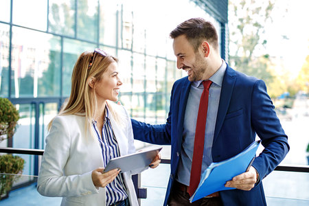 Young business people are relaxing in front of the company building and discussing about new project.の写真素材