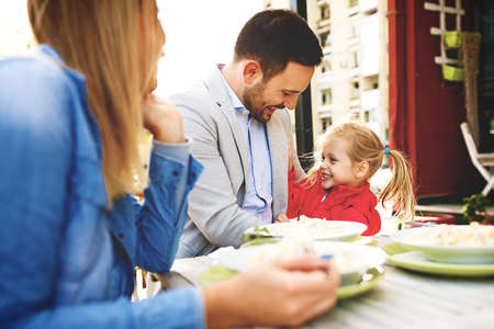Happy family is enjoying pasta in restaurant.の写真素材