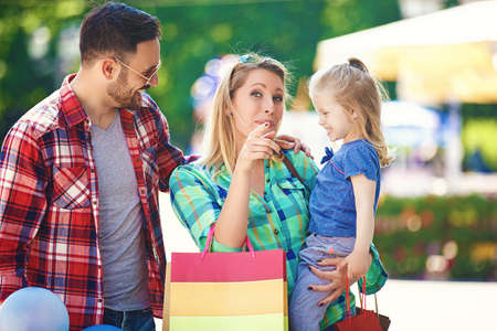 Happy family walking along the street with shopping bags.の写真素材