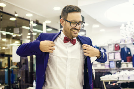 Portrait of handsome young man buying clothes in the store.
