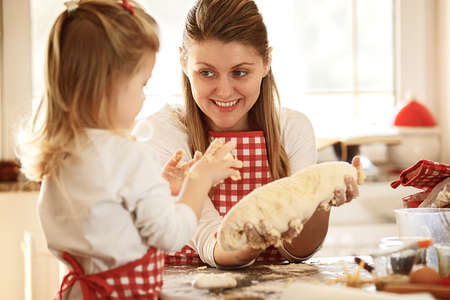 Happy family enjoying baking cakes early in the morning.の写真素材