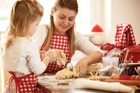 Happy family enjoying baking cakes early in the morning.の写真素材