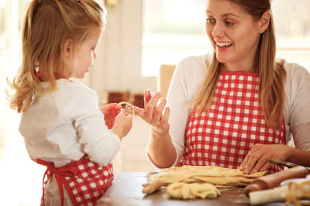 Happy family enjoying baking cakes early in the morning.の写真素材