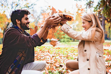 Young smiling couple enjoying fall in the park.の写真素材
