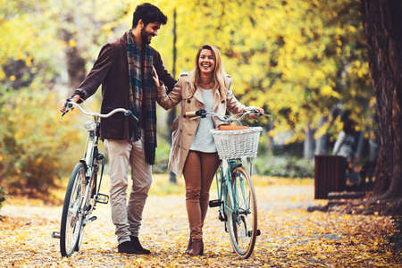 Young smiling couple enjoying fall in the park.の写真素材