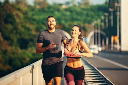 Couple is exercise on the bridge early in the morning.の写真素材