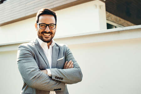 Young smiling businessman in front company building.の写真素材