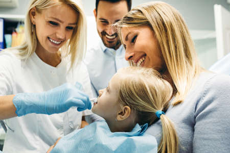 Female dentist and young girl patinet in dentist office.の写真素材