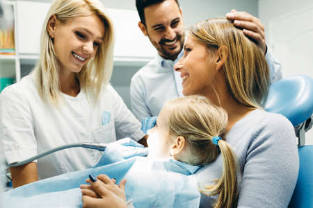 Female dentist and young girl patinet in dentist office.の写真素材