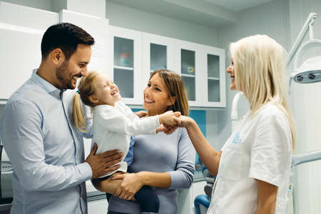 Female dentist and young girl patinet in dentist office.の写真素材
