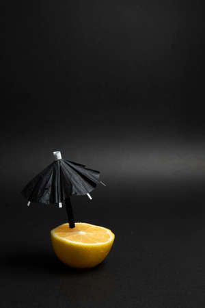 Lemon on black background. Black umbrella. Creative minimal helloween idea.の写真素材