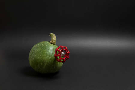 Green pumpkin with valve in it. Halloween decoration. Cool. Original photo. Black background.の写真素材
