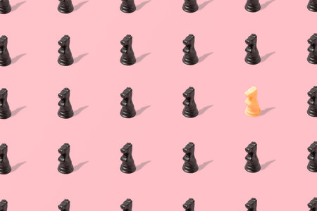 Trendy pink pattern made of black chess figure knights, with one different white knight. Pink background. Minimal and chess concept.の写真素材