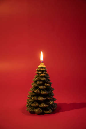 Candle Christmas tree on red background.の写真素材