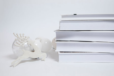 White deer, reindeer, New Year's decoration and books on a white background. Christmas and holiday...
