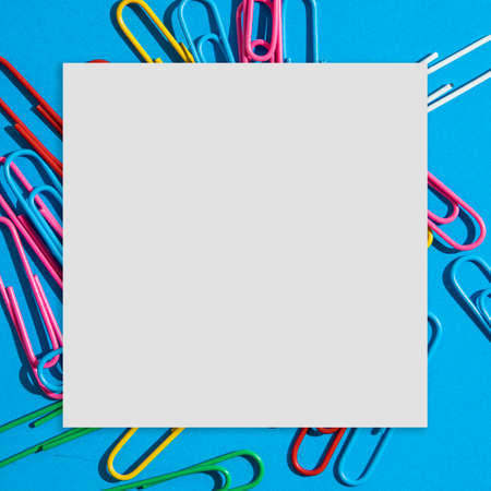 Creative layout made colorful paper clips on a blue background. Cube paper card.  School, and eduaction idea.の写真素材