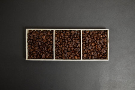 a wooden box full of coffee beans. Black background.