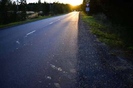 glare and shadows on the pavement in the eveningの写真素材