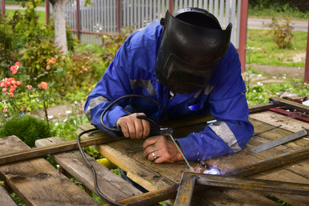 electric welder welds metal parts