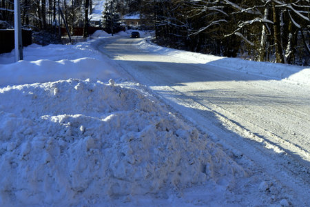 snowdrift by the road through the villageの写真素材