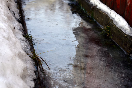 the sidewalk is covered with melting iceの写真素材