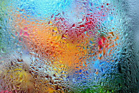 the illusion of color in drops of condensation on a window paneの写真素材