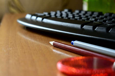 pencil and pen by the keyboardの写真素材