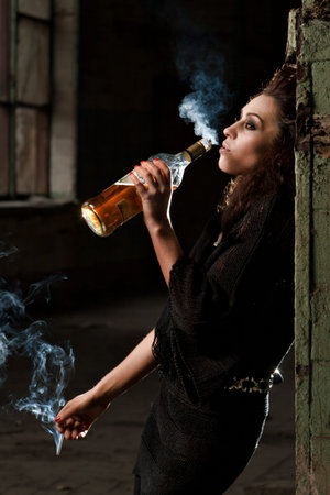 woman smokes in the dark room の写真素材