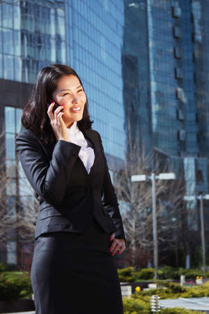 Portrait of a cute business woman over business center on backの写真素材
