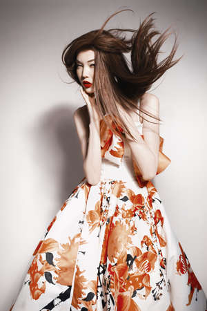 young beautiful asian brunette in gorgeous dress, motion shotの写真素材