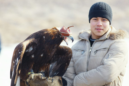 NURA, KAZAKHSTAN - FEBRUARY 23: Eagle on man's hand in Nura near Almaty on February 23, 2013 in...