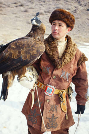 NURA, KAZAKHSTAN - FEBRUARY 23: Eagle on man's hand in Nura near Almaty on February 23, 2013 in Nura, Kazakhstan. The traditional event happens yearly and the place becomes as a medieval times city.のeditorial素材