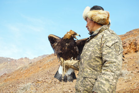 NURA, KAZAKHSTAN - FEBRUARY 23: Eagle on man's hand in Nura near Almaty on February 23, 2013 in...