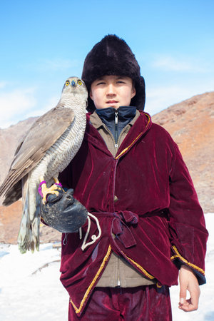 NURA, KAZAKHSTAN - FEBRUARY 23: Eagle on kid's hand in Nura near Almaty on February 23, 2013 in...