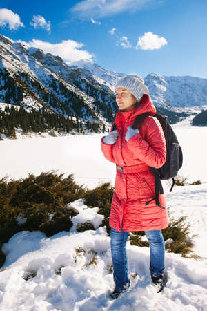Young woman take a walk on winter mountain slope (Big Almaty Lake, Kazakhstan)の写真素材