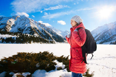 Young woman take a walk on winter mountain slope (Big Almaty Lake, Kazakhstan)の写真素材