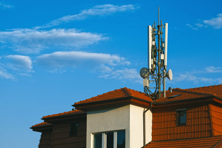 Living building with GSM antennas on roof isolated on blue sky