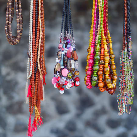 The multi colored beads necklaces hanging on a grey backgroundの写真素材