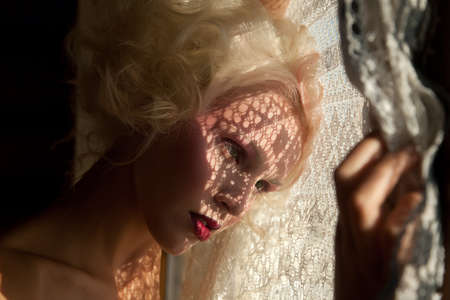 Lovely girl watching through the windowの写真素材