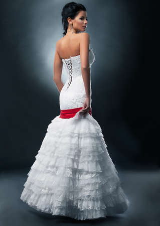 Spectacular fashion model brunette in wedding dress posing on podiumの写真素材