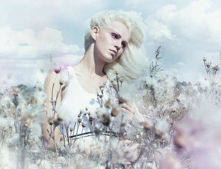 Beautiful gentle blonde girl in flowering meadowの写真素材
